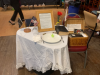 Table for the Missing with bible,  American  and POW flags, upside down wine glass, and empty place setting. Journals for memories of lost loved ones and friends in a basket on the side at the 2022 Tom Paine Party.