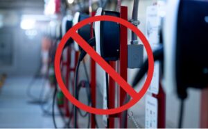 Red circle with slash on bank of EV chargers denoting DeSantis holding on to EV charger millions.