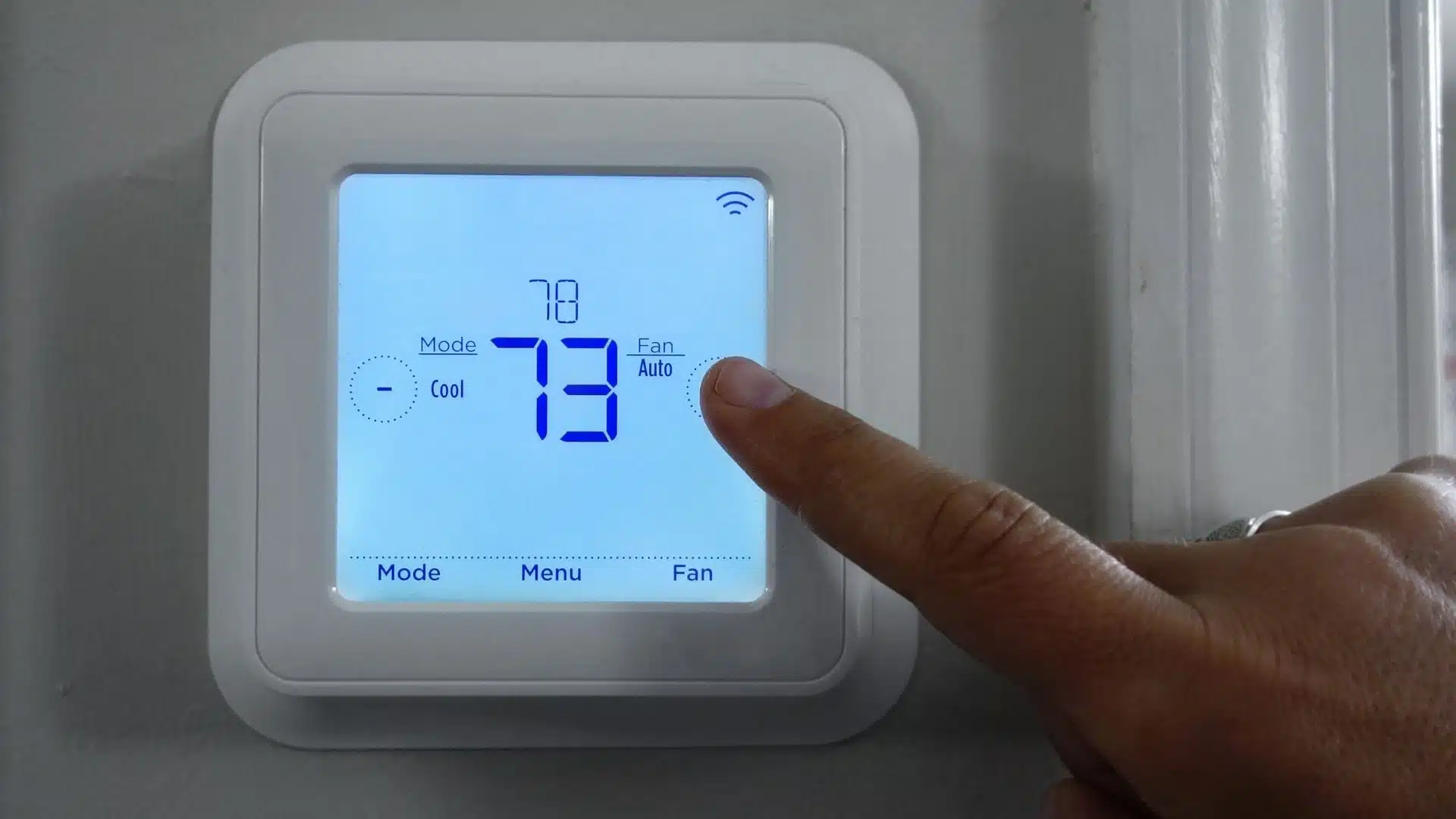 Finger adjusting Smart Thermostat to a higher temperature. It highlights the cost to lower income people of Stuebe's vote to repeal HEHRP.